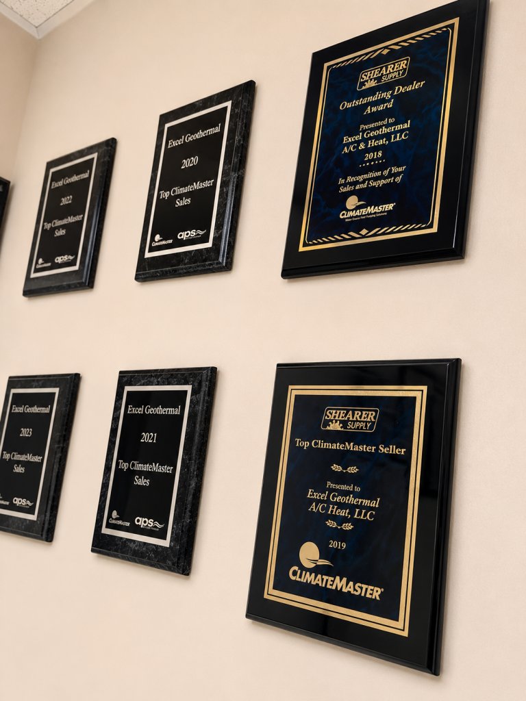 Wall of ClimateMaster Top Seller and Shearer Supply Outstanding Dealer award plaques earned by Excel Geothermal A/C & Heat