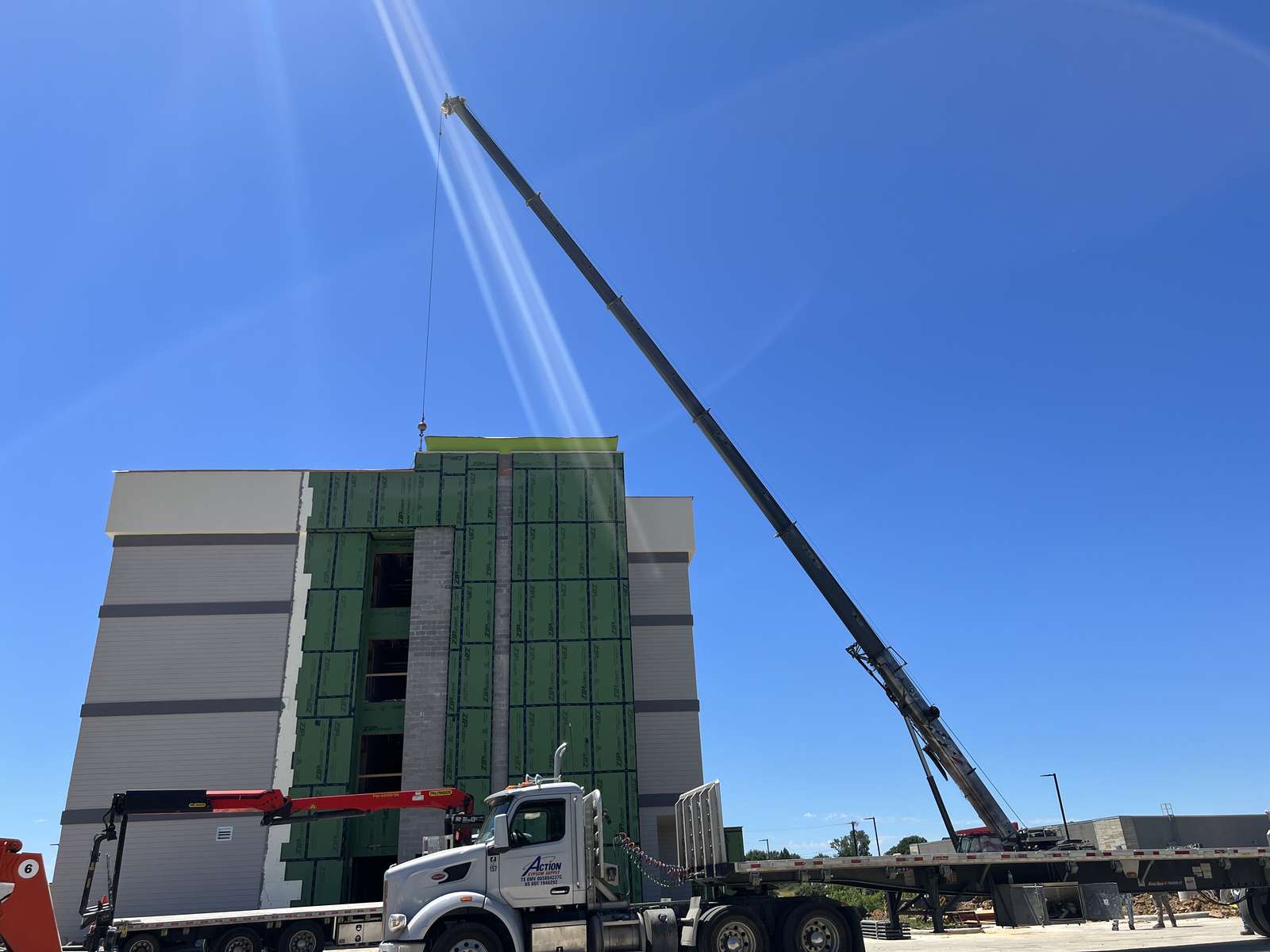 Crane boom extended high over the Home2 Suites building under construction in Paris, Texas